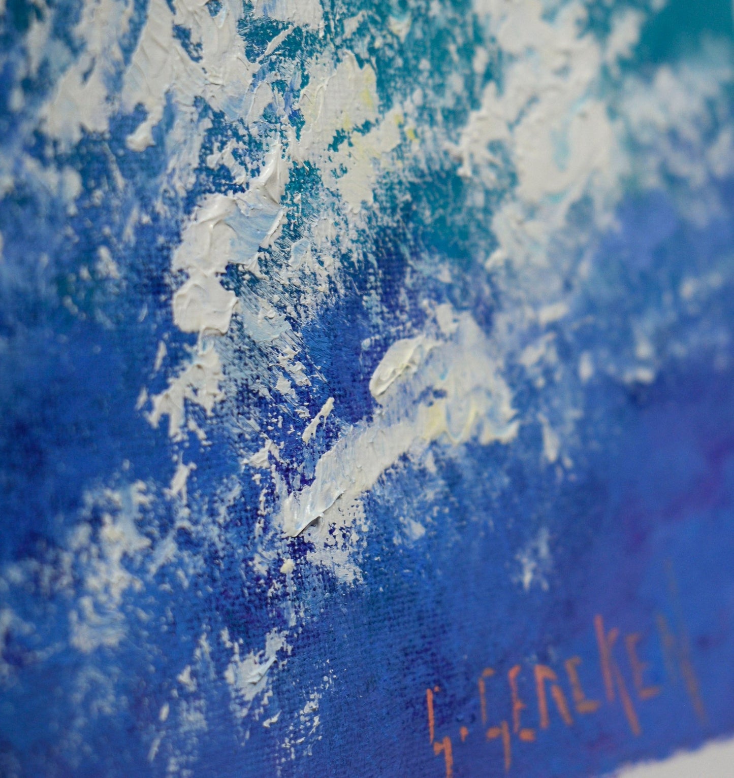 Close-up of a textured blue and white painting with a signature.