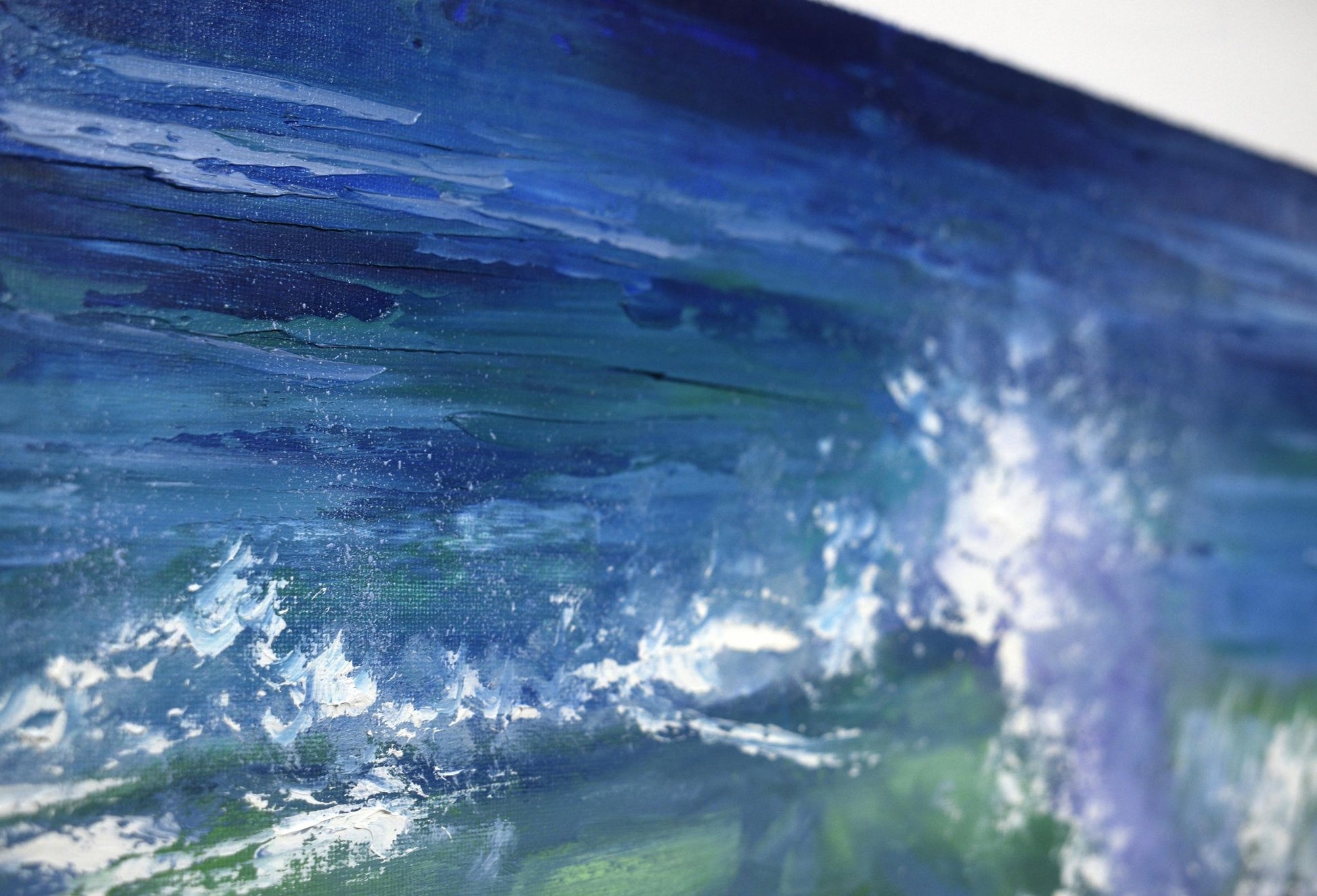 Close-up of a painting of a wave with blue and green colors.