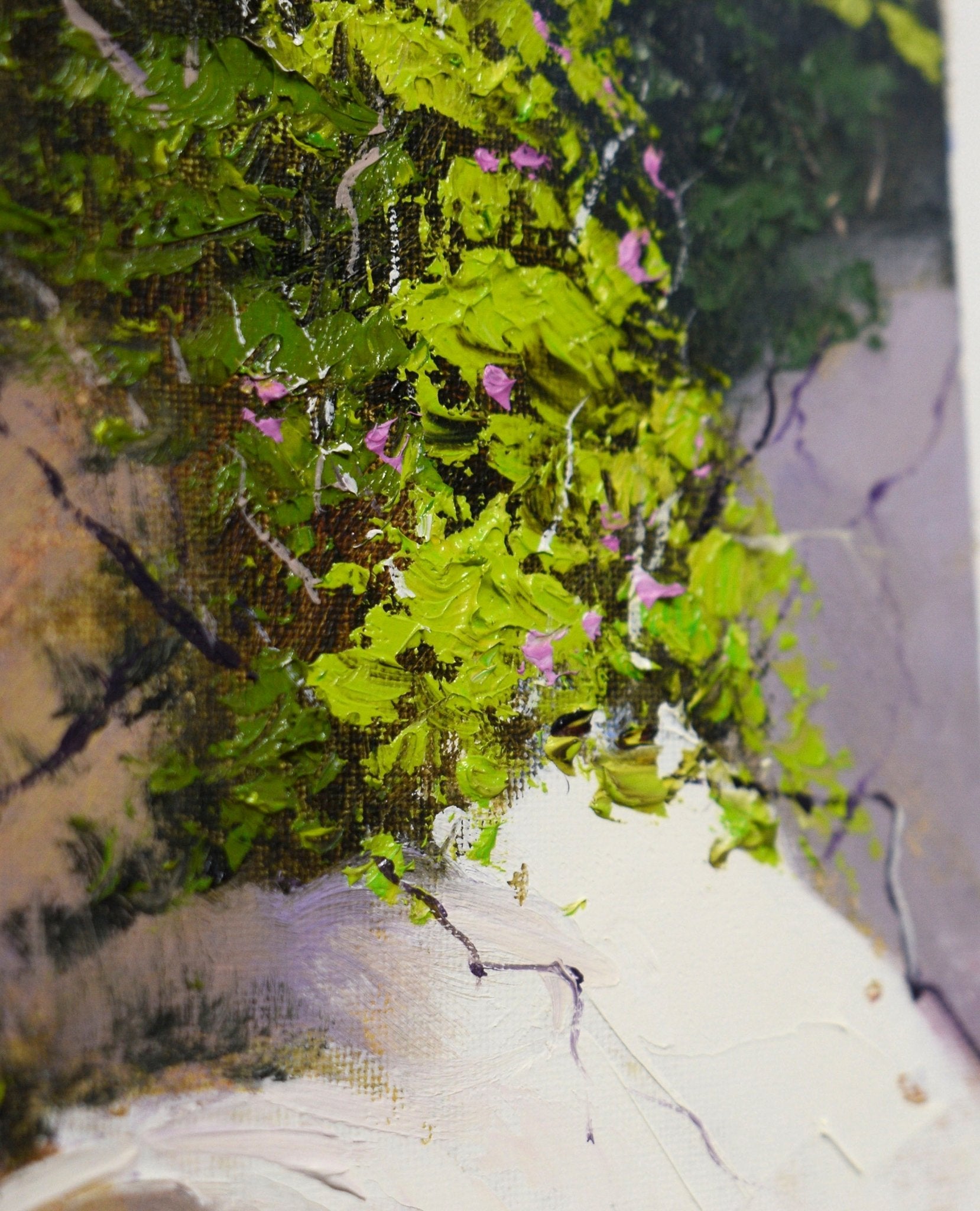 Close-up of a textured green surface with pink flowers on a marble-like background