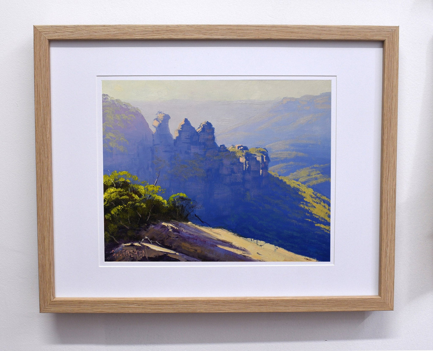 Framed painting of a mountain landscape with a wooden frame.