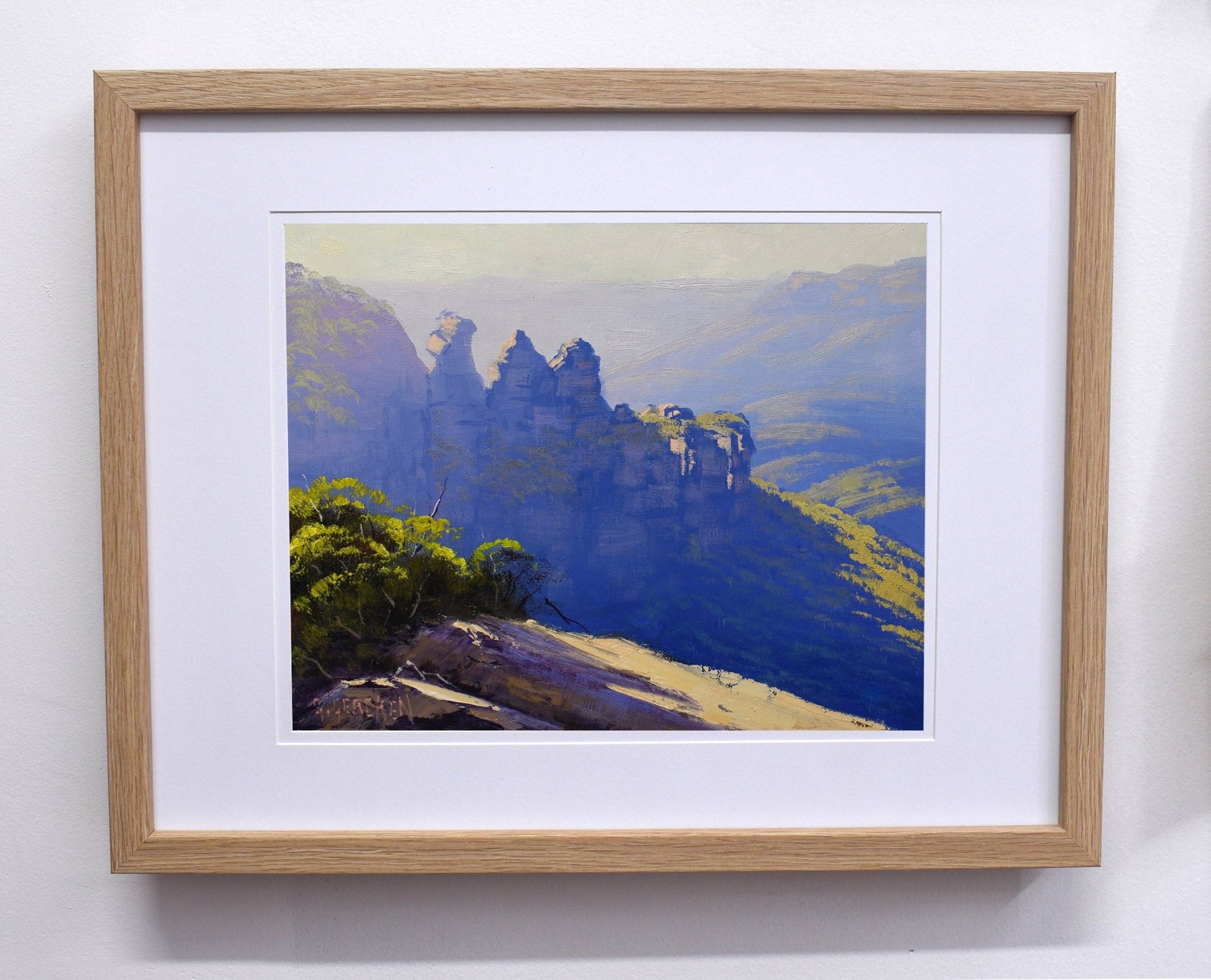 Framed painting of a mountain landscape with a wooden frame.