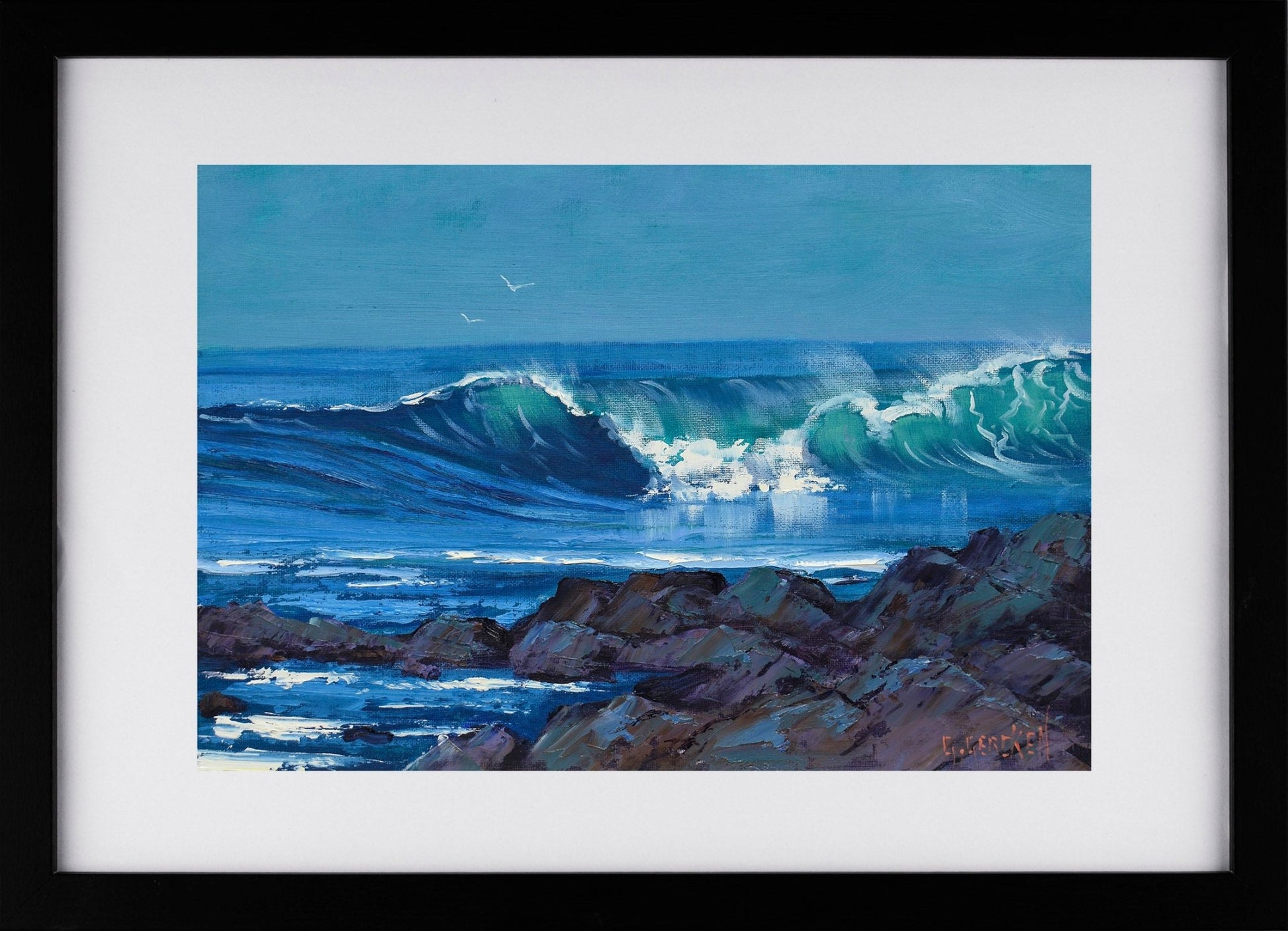 Framed artwork of a wave crashing against rocks with a clear blue sky.