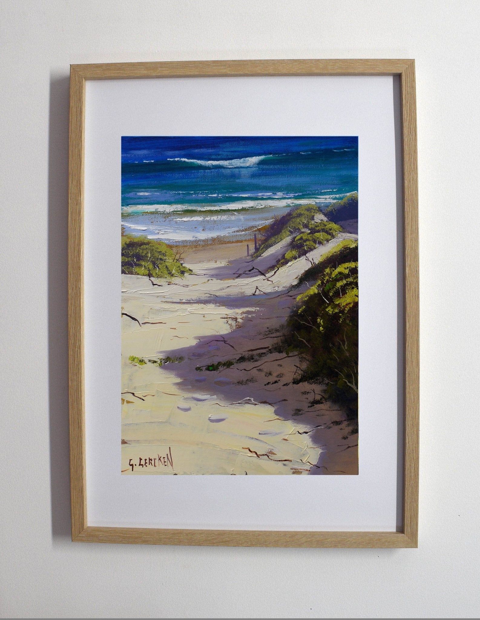 Framed painting of a beach scene with waves and sand.