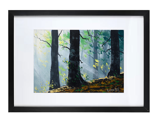 A framed forest painting featuring tall dark tree trunks, soft blue-gray misty light rays, green foliage, and golden-yellow ground cover, presented in a black frame with a white mat.